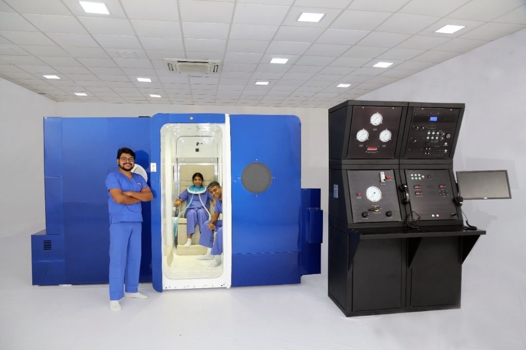 The Rockledge multiplace hyperbaric chamber during treatment with patients seated inside and clinical team monitoring from the console